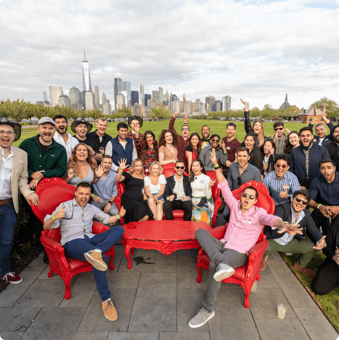 a large group of people are posing for a picture in front of a city skyline