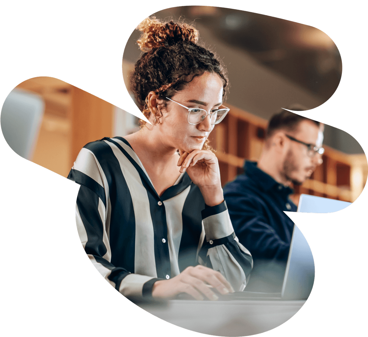 a woman wearing glasses is typing on a laptop