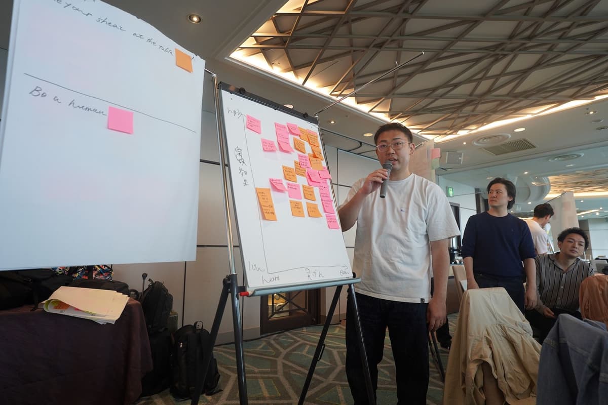 a man is standing in front of a whiteboard talking into a microphone .