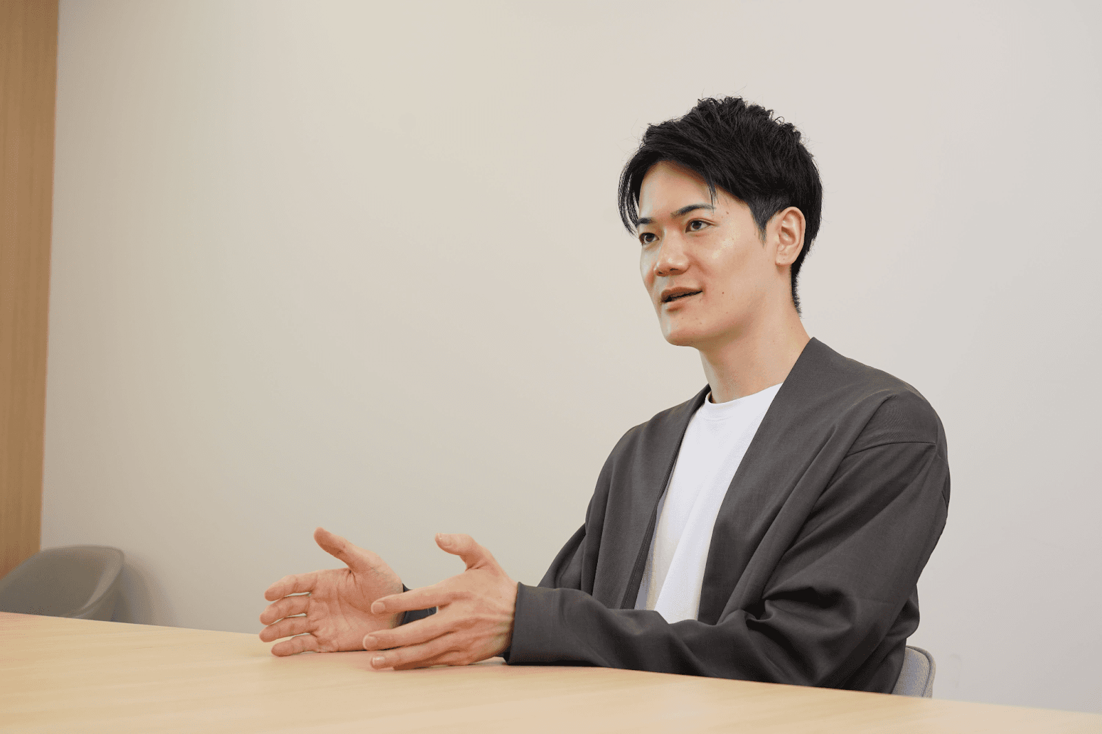 a man sitting at a table with his hands outstretched
