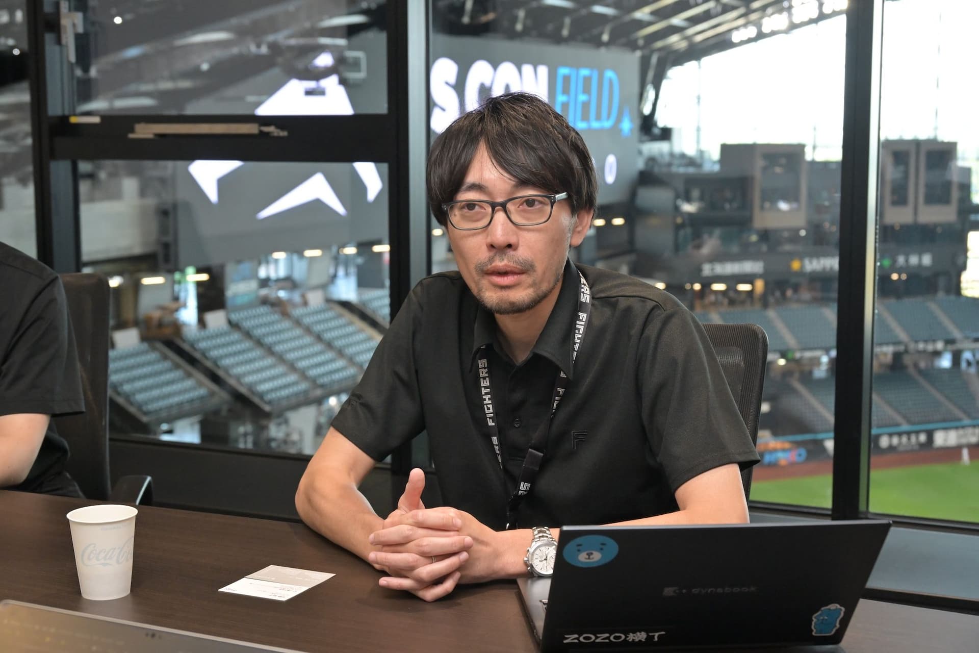 a man is sitting at a table with a laptop and a cup of coffee .