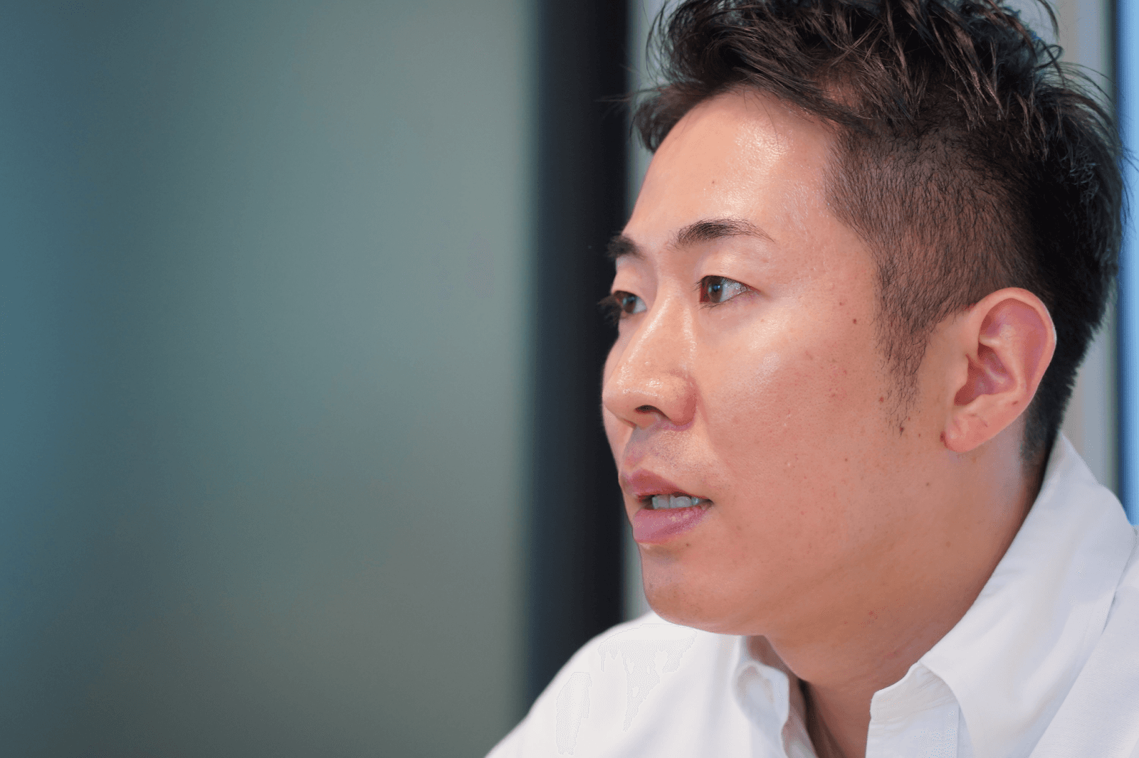 a close up of a man 's face with a white shirt on
