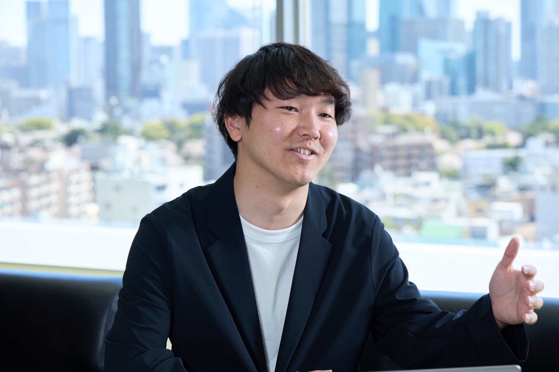 a man in a suit is sitting on a couch in front of a window .