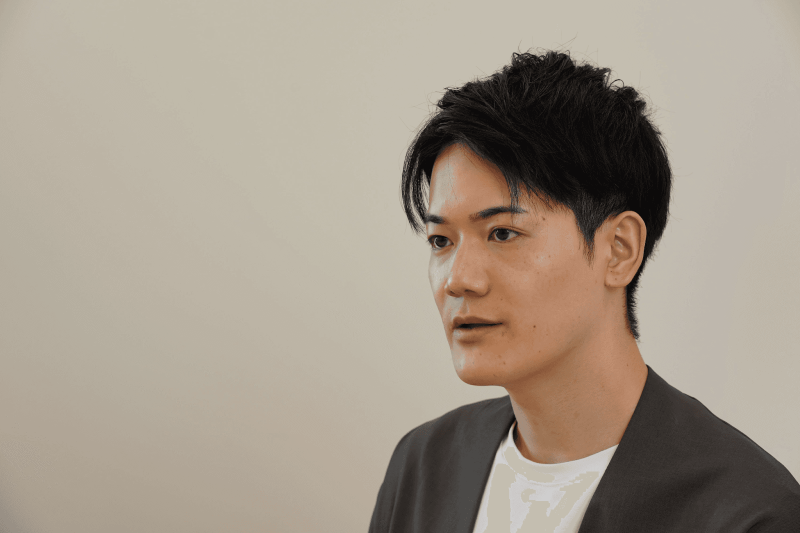 a man in a suit and white shirt looks to the side