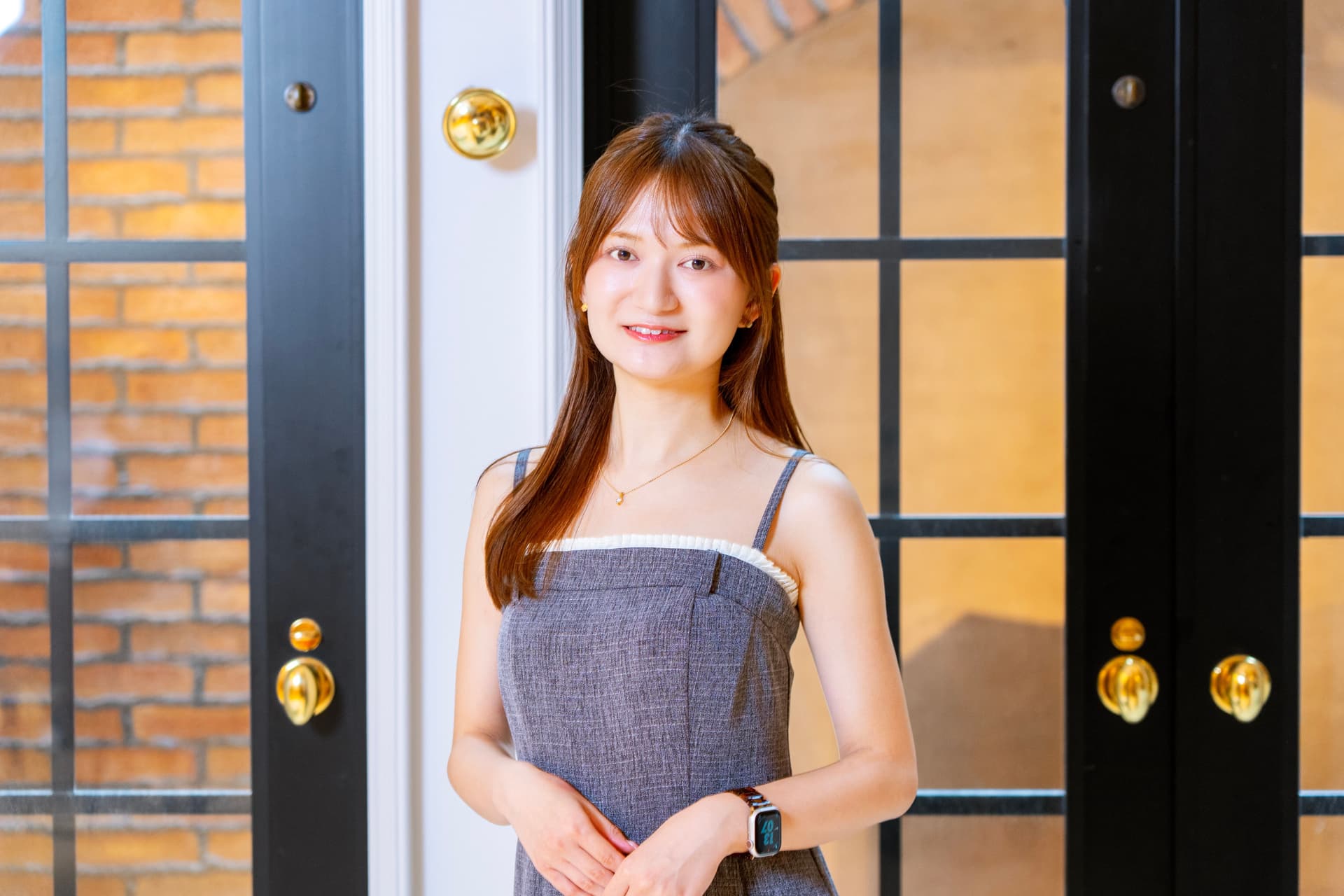 a woman in a dress is standing in front of a window .