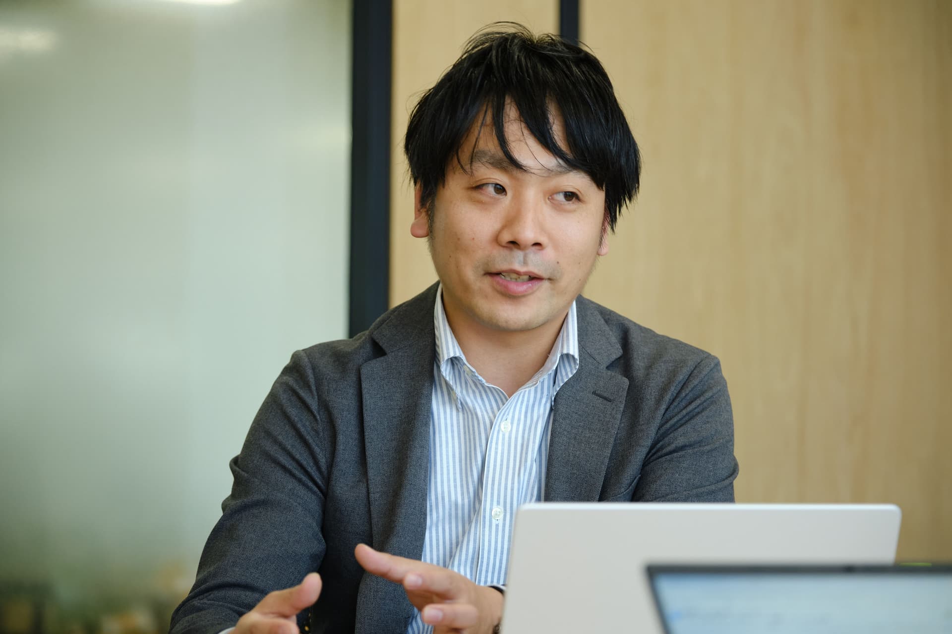 a man in a suit is sitting in front of a laptop computer .