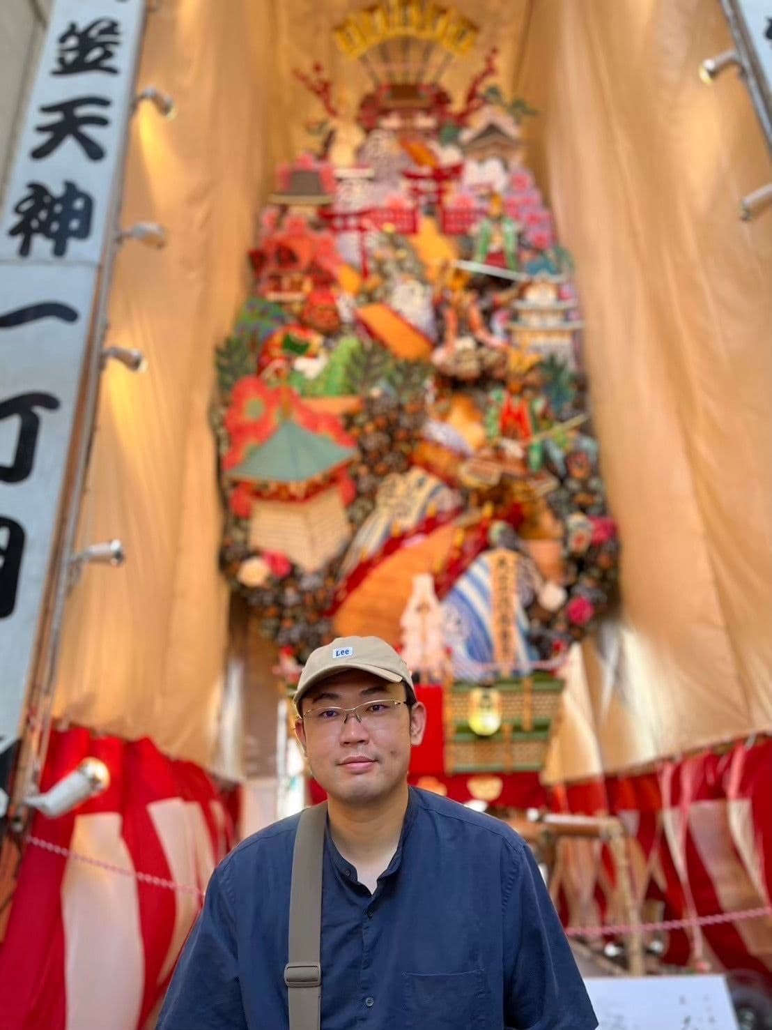 a man standing in front of a large statue with chinese writing on it