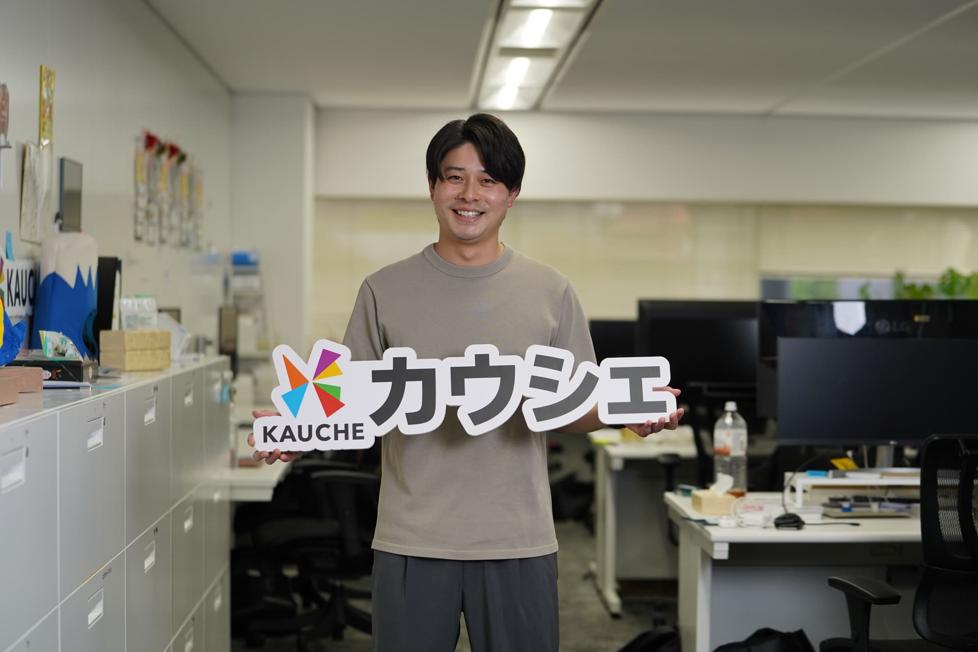 カウシェ執行役員CMOの前本航太さんがカウシェのロゴをもっている