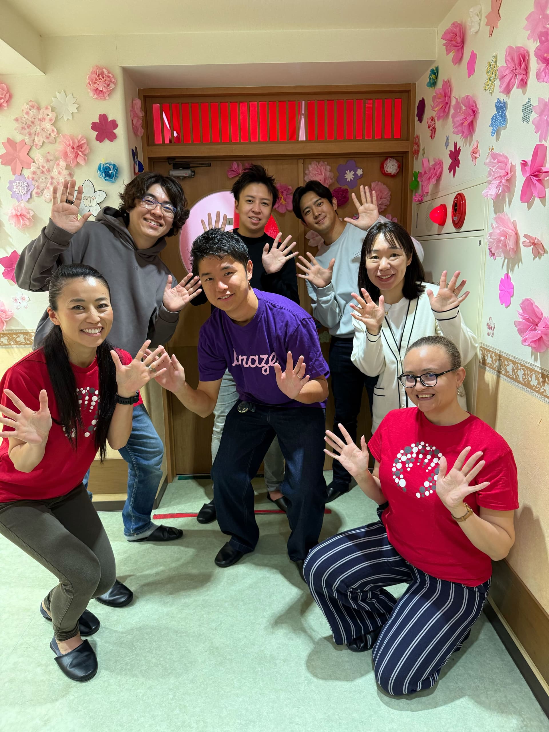 a group of people posing for a picture with one wearing a purple shirt that says ' arazu ' on it