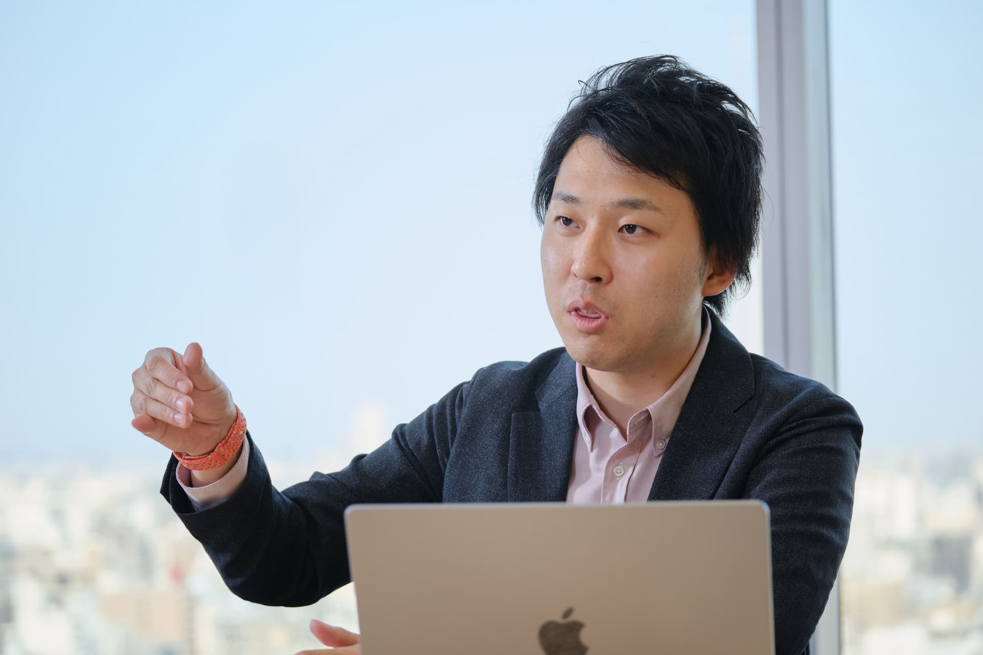 a man in a suit is sitting in front of a laptop computer .