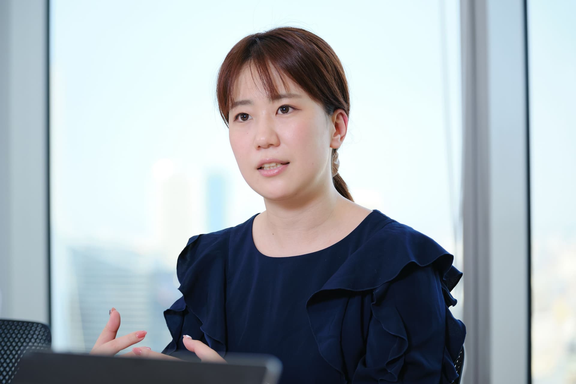 a woman in a blue dress is sitting in front of a laptop computer .