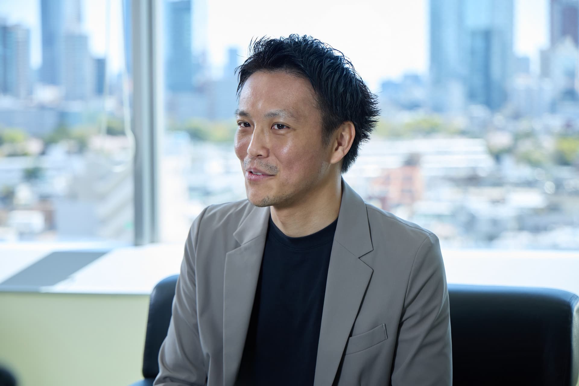 a man in a suit is sitting on a couch in front of a window .