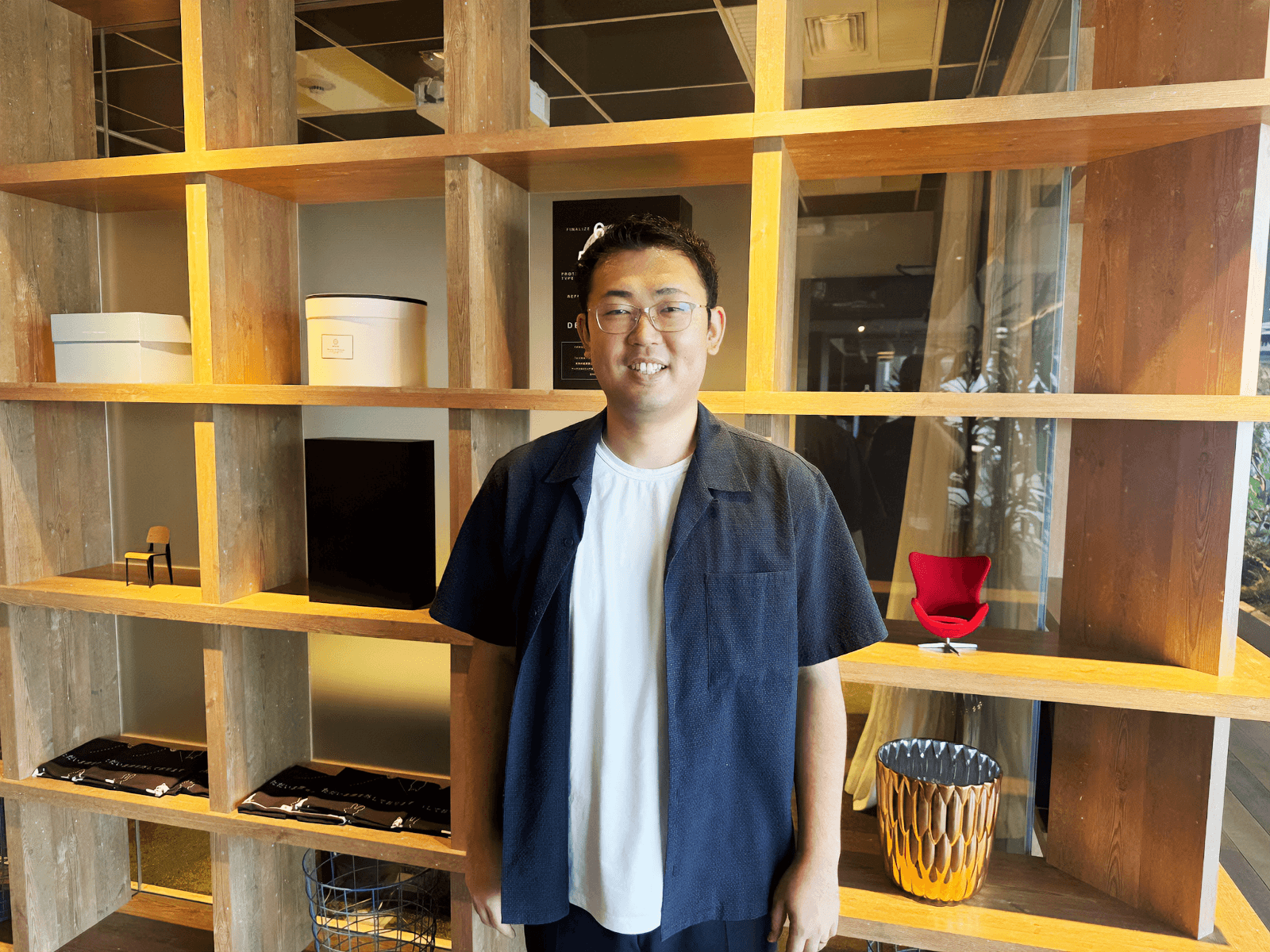 a man stands in front of a shelf with a sign that says ' a ' on it
