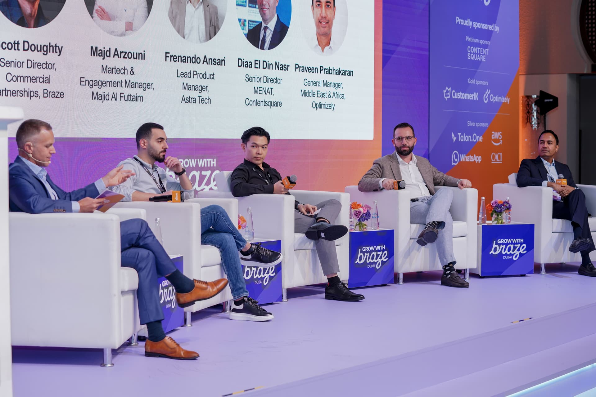 five speakers seated in chairs on a stage