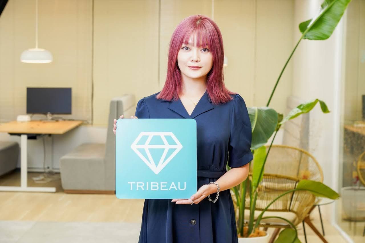 a woman with pink hair is holding a blue sign with a diamond on it .