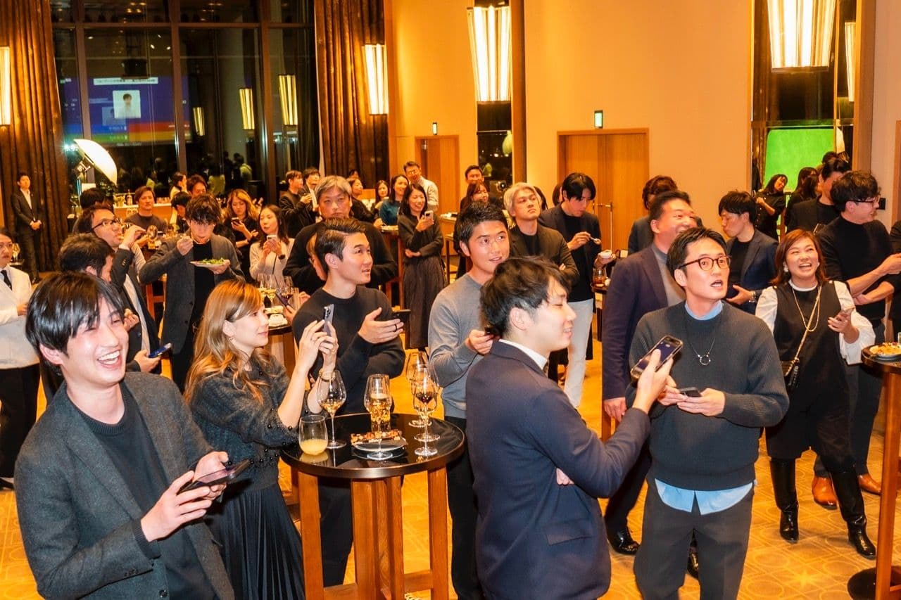 a large group of people are standing around tables at a party .