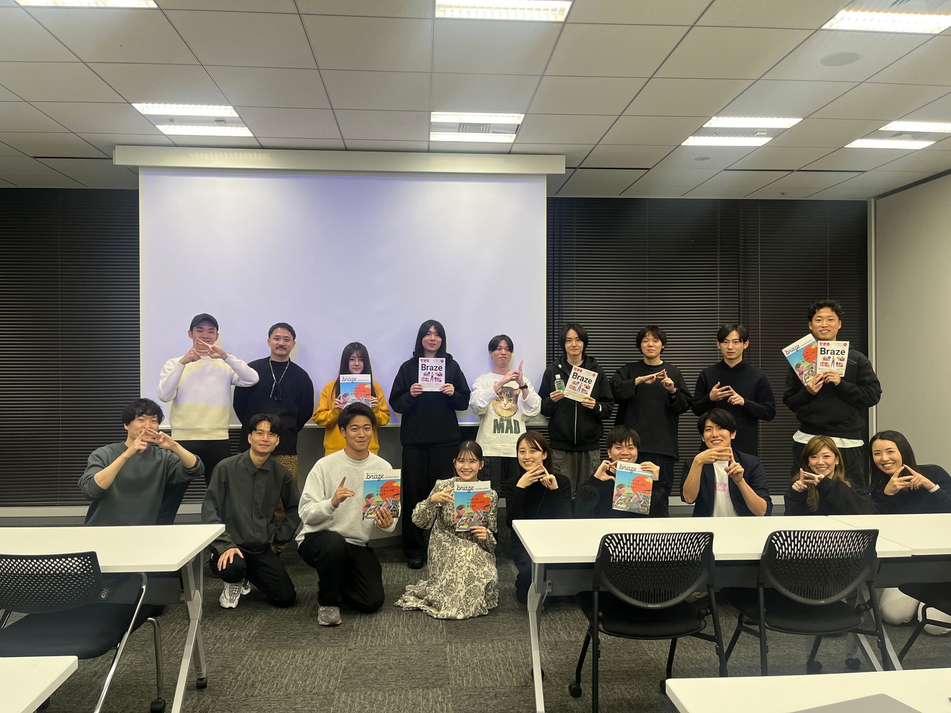 a group of people are posing for a picture in a classroom while holding books